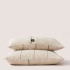 Cushion from the ABANS collection in 100% European linen "Masters of Linen" ®, featuring natural tones and subtle stitched lines, inspired by the art of basketry. Cojín de diseño Abans 100% lino europeo certificado en tono crudo con franjas en negro