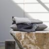 Cojin y manta de lino europeo con textura voluminosa en tonos grises y azules