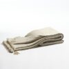 Manta de lana merino tejida en telar manual con trazabilidad en colores neutros con perfiles internos en gris doblada