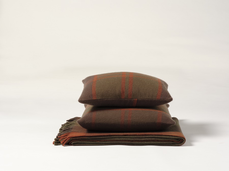 Cojines de diseño en lana cashmere en tonos marrones verdosos con franjas naranja y manta a juego