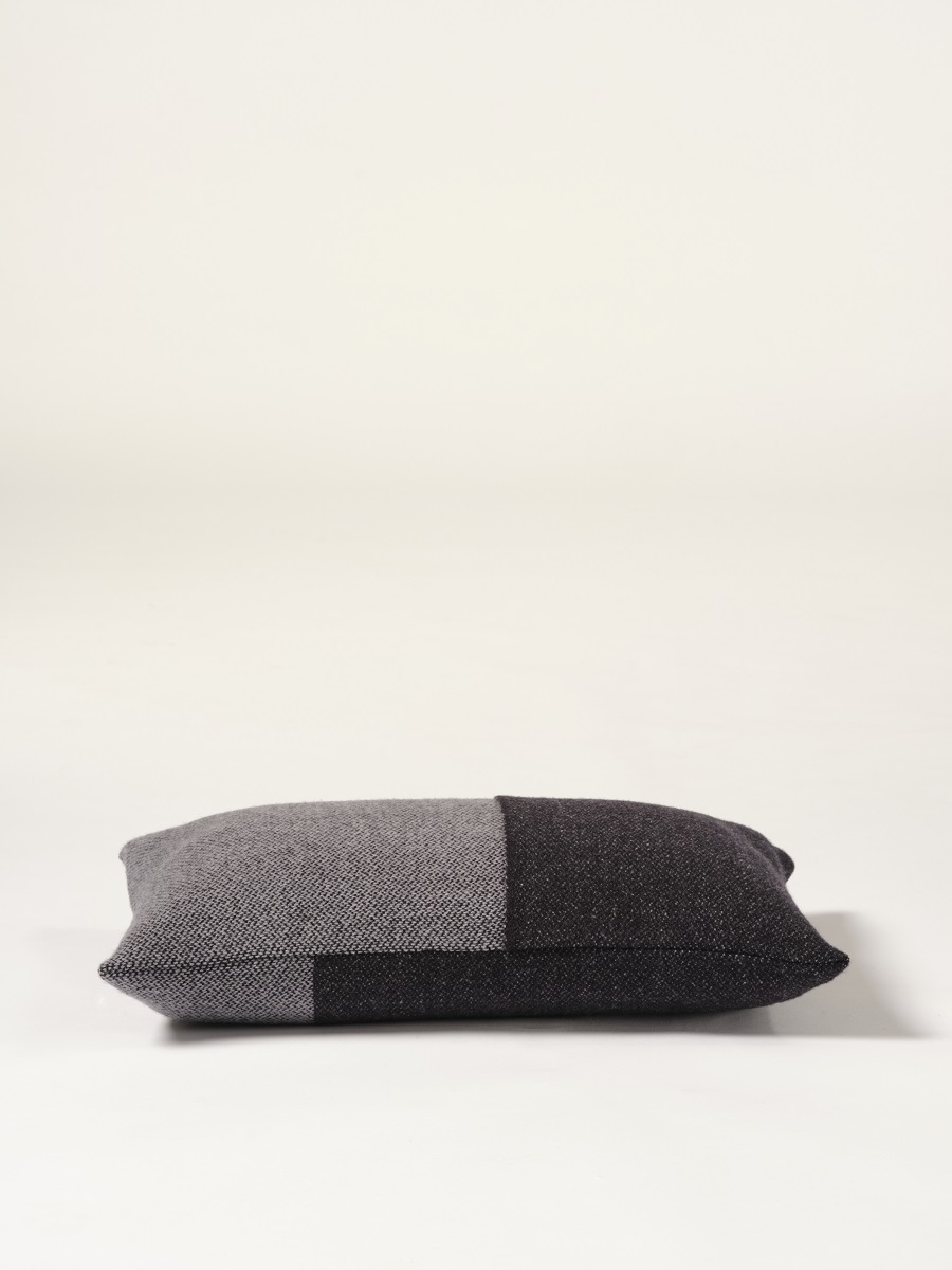 Cojín de diseño Teixidors en lana merino en color gris y negro. Foto de estudio con cojín de diseño con fondo blanco.