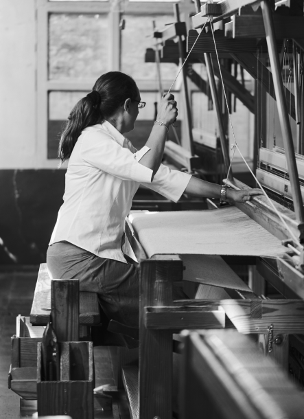 Mujer tejiendo en el taller de Teixidors en telar manual  de madera