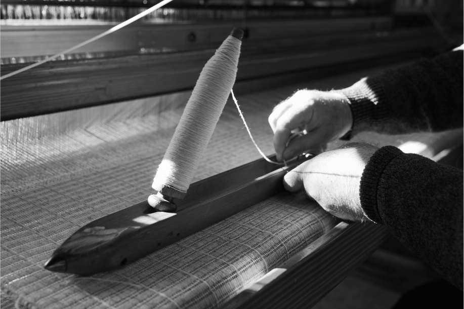 Preparando la canilla en el taller de Teixidors para comenzar a tejer en el telar manual