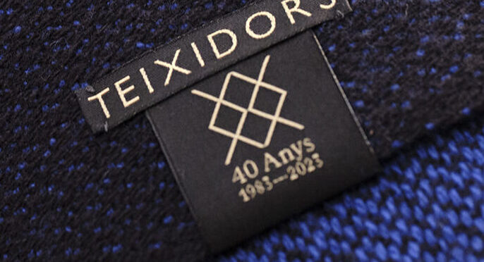Cojín de diseño en lana merino con etiquetado especial 40ª aniversario en negro y dorado