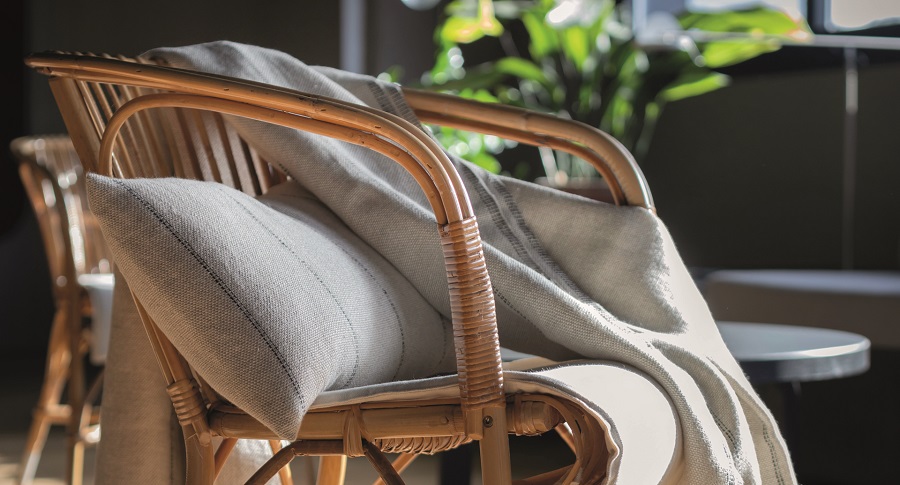 cojin y manta de lino europeo en tonos crudos sobre silla de madera