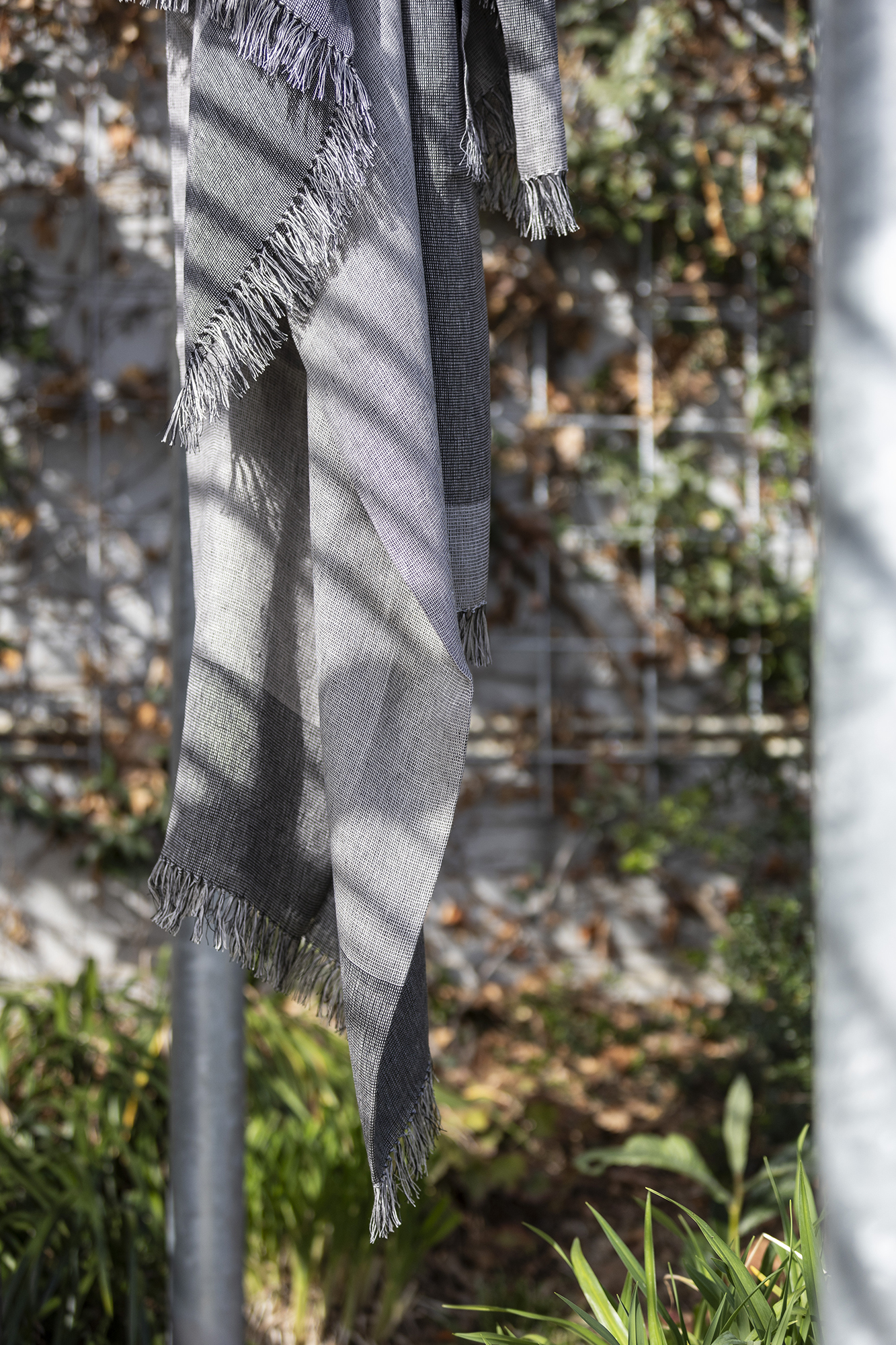 Detalle de flecos de manta de lino europeo en tonos grises 