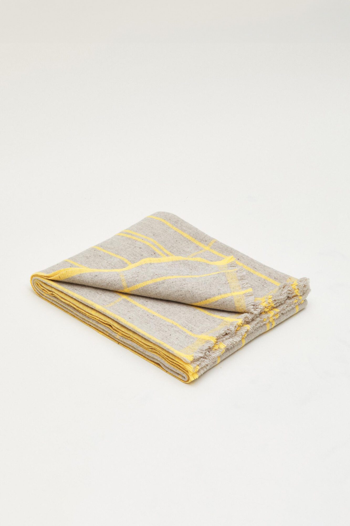 Colaboración Teixidors x Monocle plaid de lana merino local trazable detalle de las líneas en amarillo intenso de urdimbre